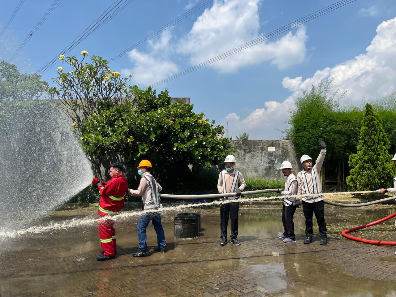 Instruktur dan peserta Wahana Totalita mempraktikkan penggunaan selang pemadam di luar ruangan